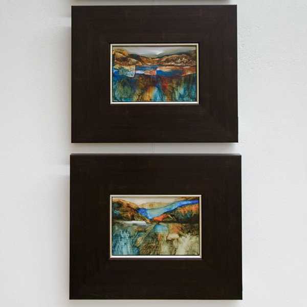 Two framed landscape paintings at an exhibition